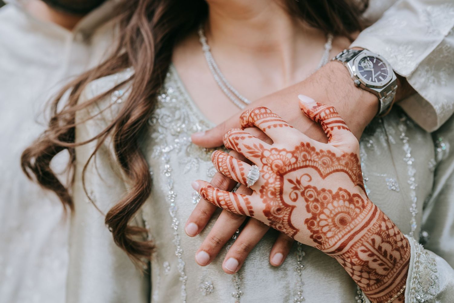 Close-up of bride’s hands with henna and wedding ring during traditional Dallas wedding.