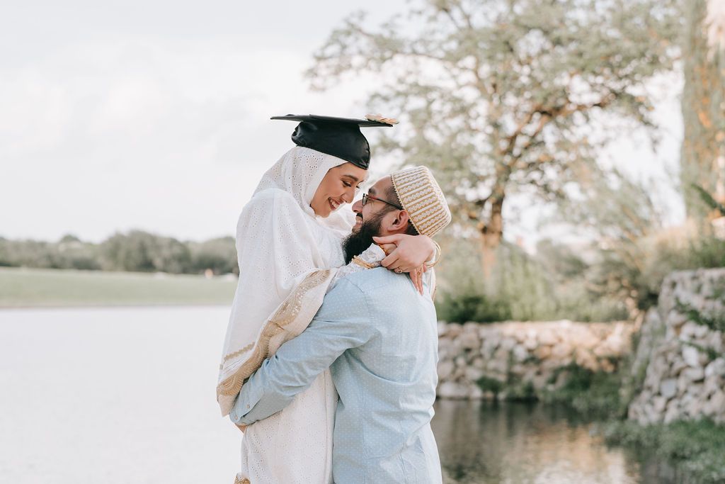 A touching graduation celebration moment captured by the water on a cloudy day.