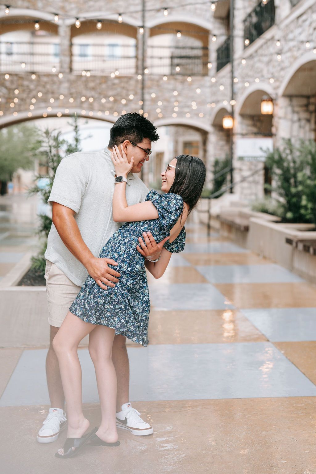 A romantic dance dip pose in a beautifully lit stone corridor with string lights.