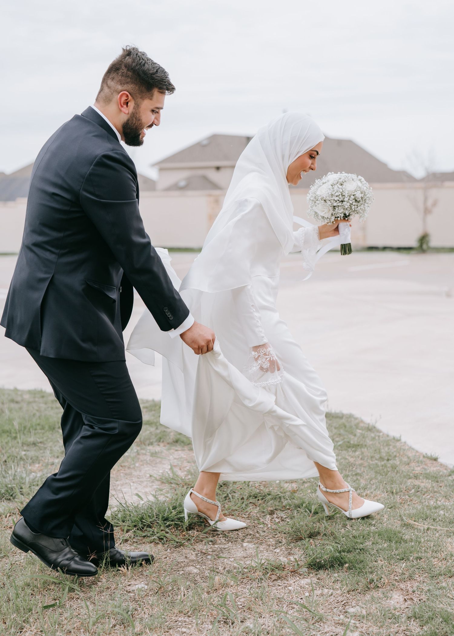 Bride and groom walking hand in hand through a field during outdoor Dallas wedding.