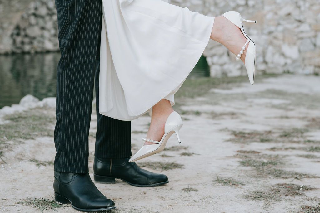 Close-up of formal shoes and dress hem during a romantic dance moment.