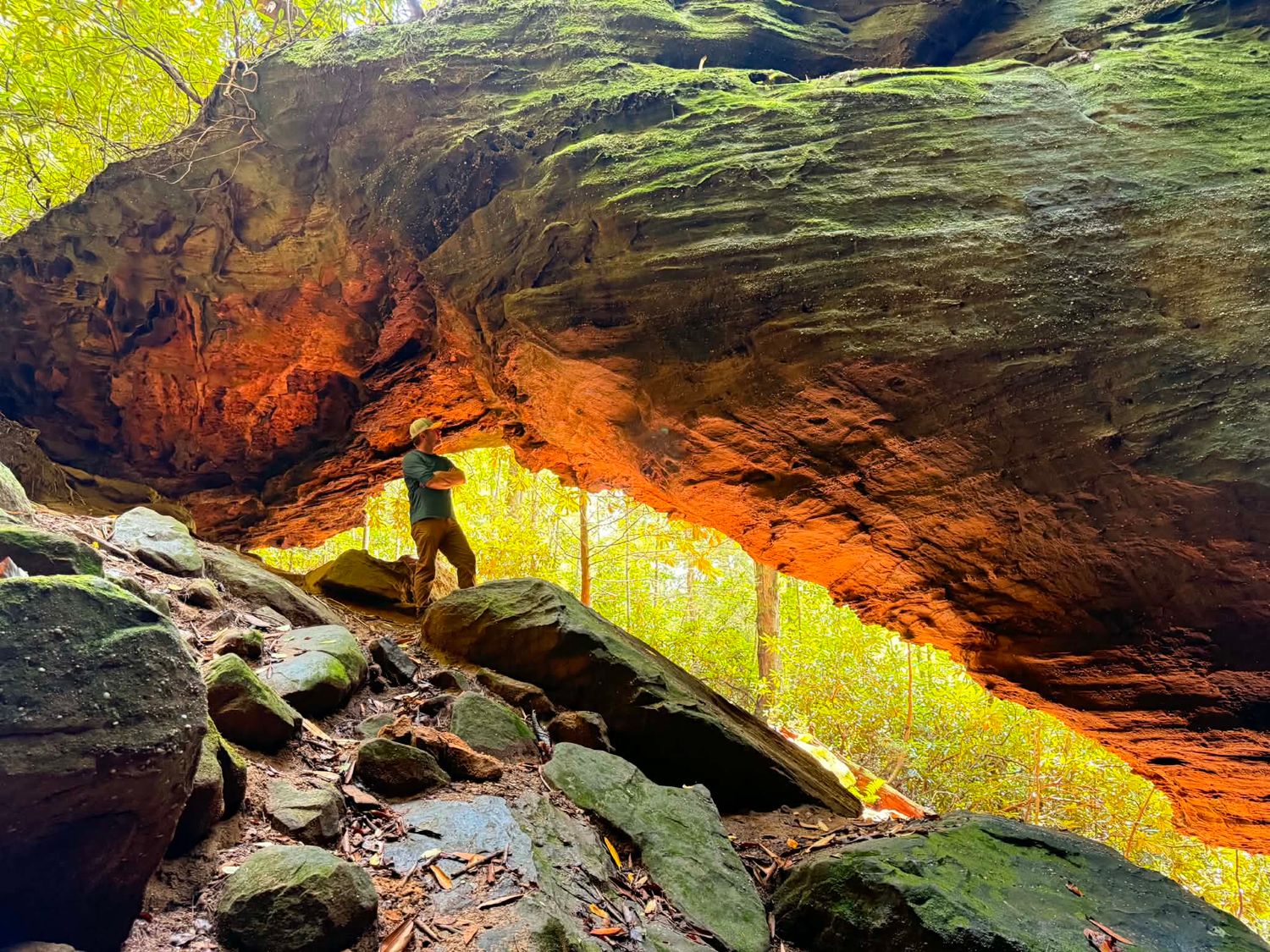 Glowing portrait beneath a natural arch at Red River Gorge, framed by warm golden light.