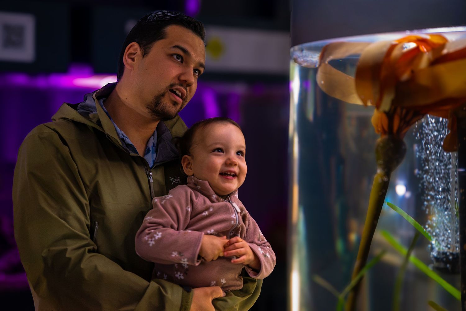 A man and his daughter looking inside an aquarium on Vancouver Island.