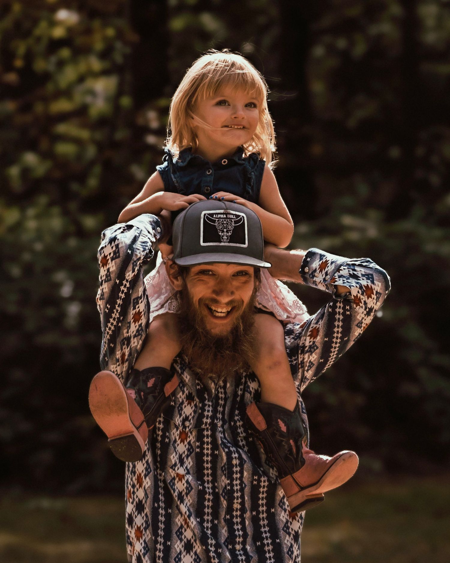 A man giving his daughter a piggyback. They are both smiling.