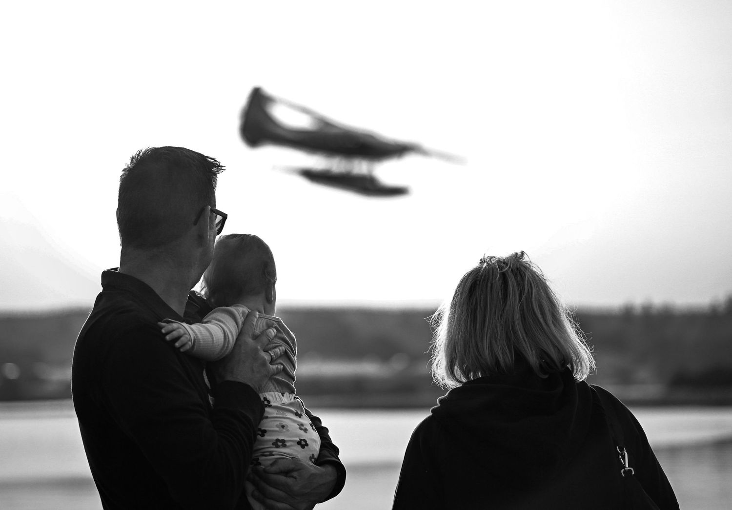 Grandparents holding a child watching a float plane land in Campbell River.