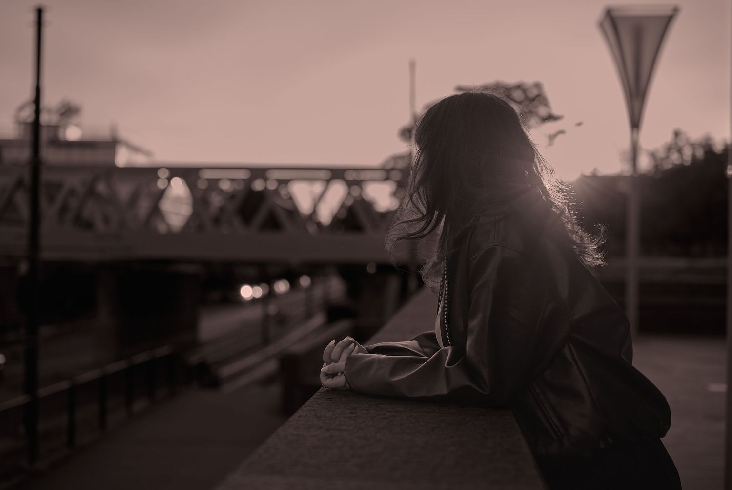 Portret feminin în lumină joasă, realizat într-un cadru urban cu atmosferă cinematică.