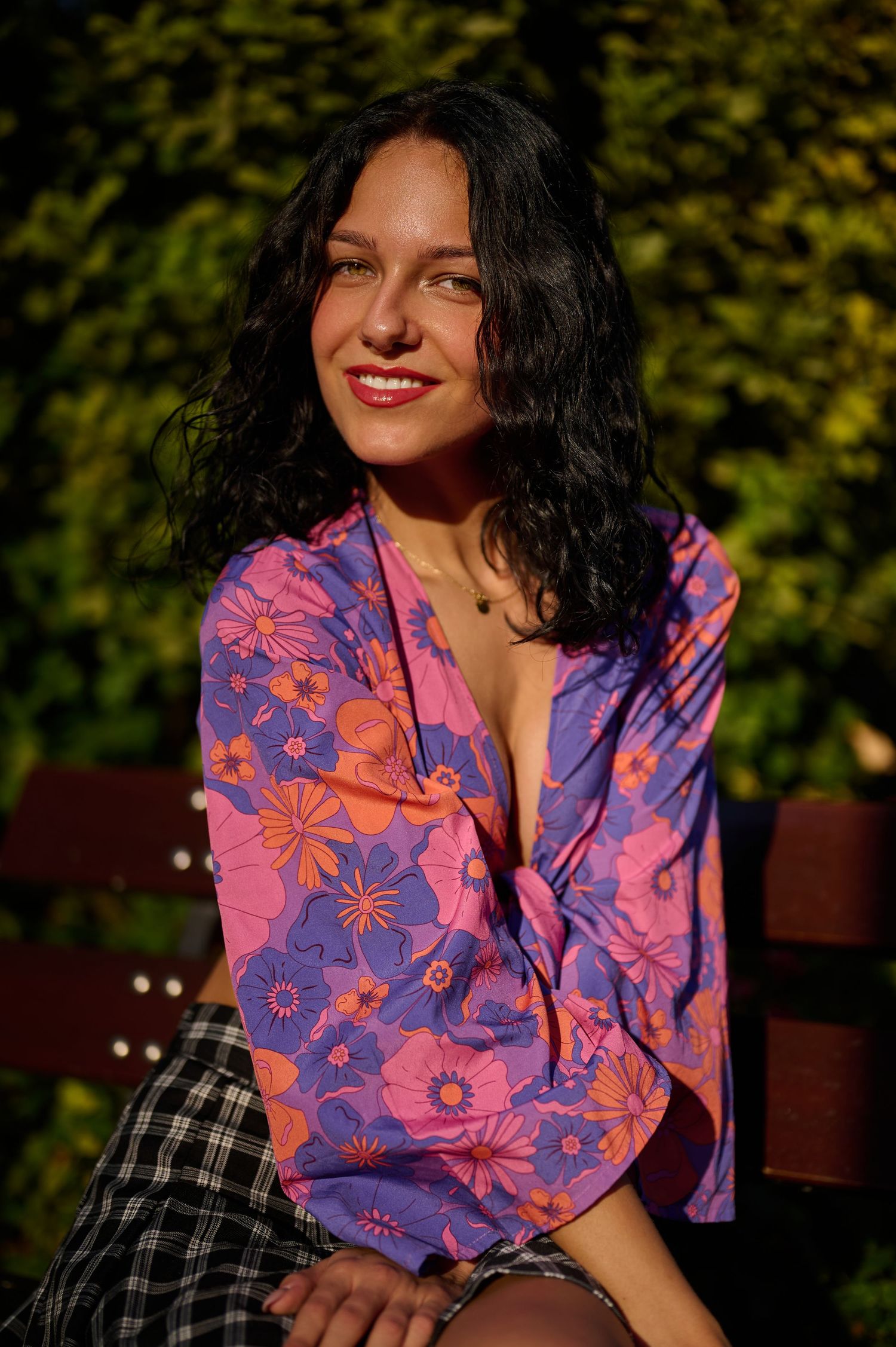 Portret feminin apropiat, cu expresie naturală și lumină caldă de exterior.