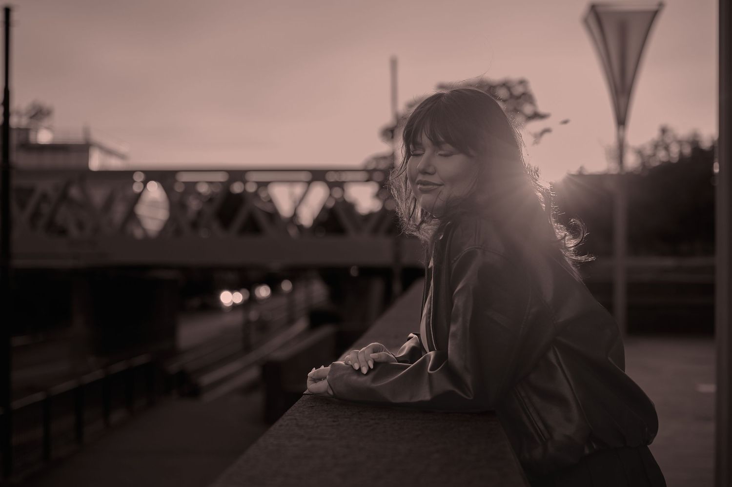 Portret feminin în lumină joasă, realizat într-un cadru urban cu atmosferă cinematică.