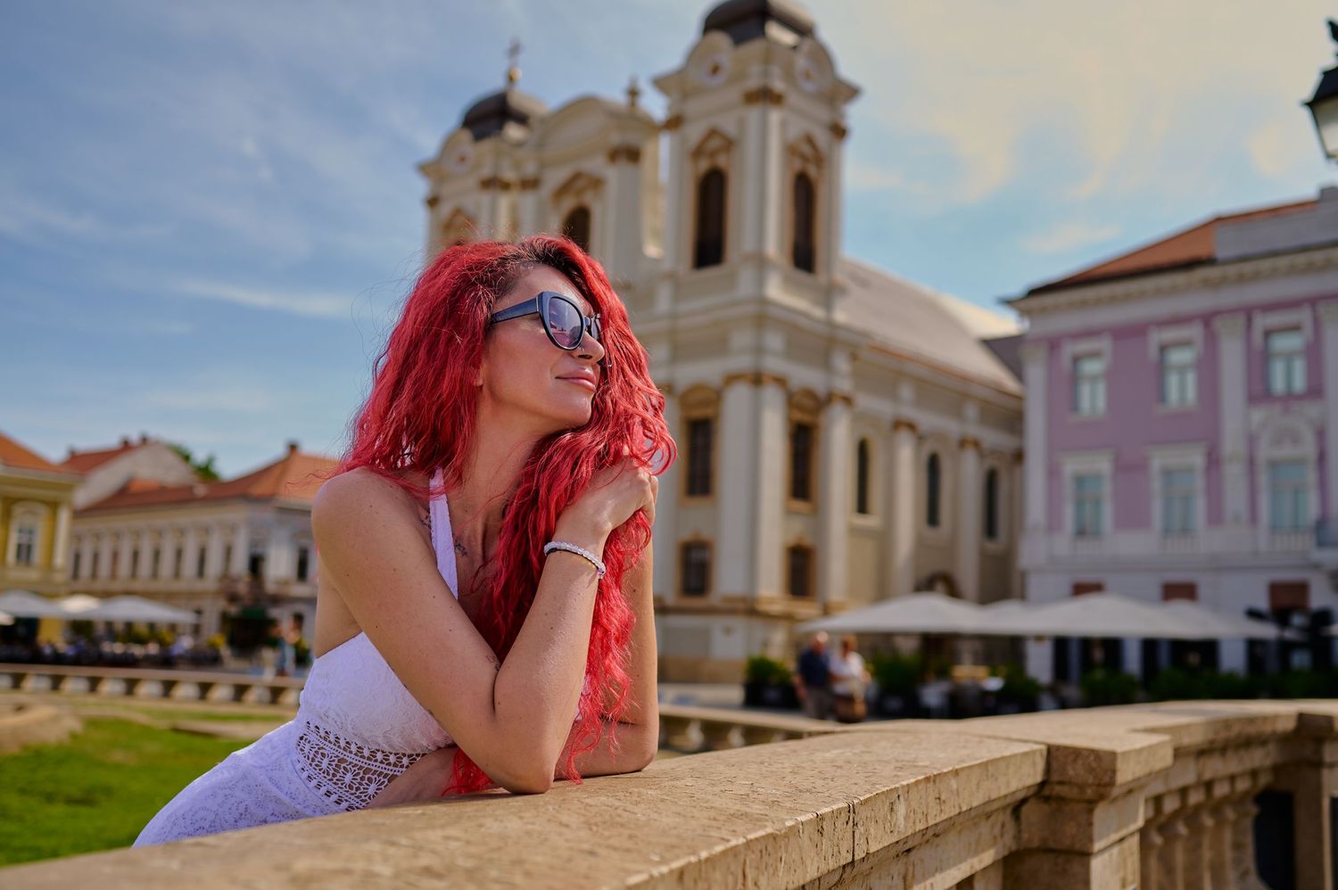 Portret feminin în Piața Unirii din Timișoara, realizat în lumină dură cu arhitectura în spate.