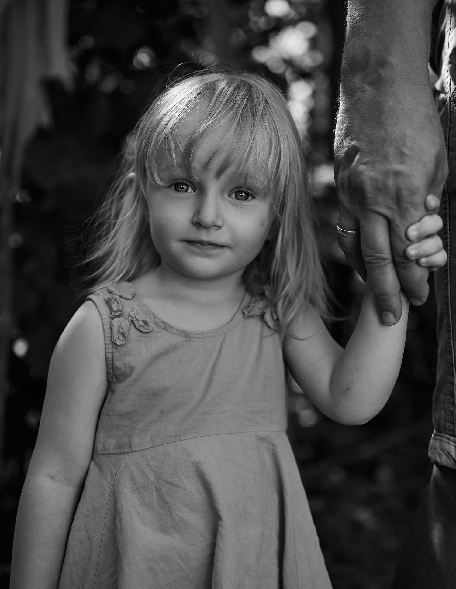 Portret alb-negru al unei fetițe, suprins într-un moment natural în grădină.