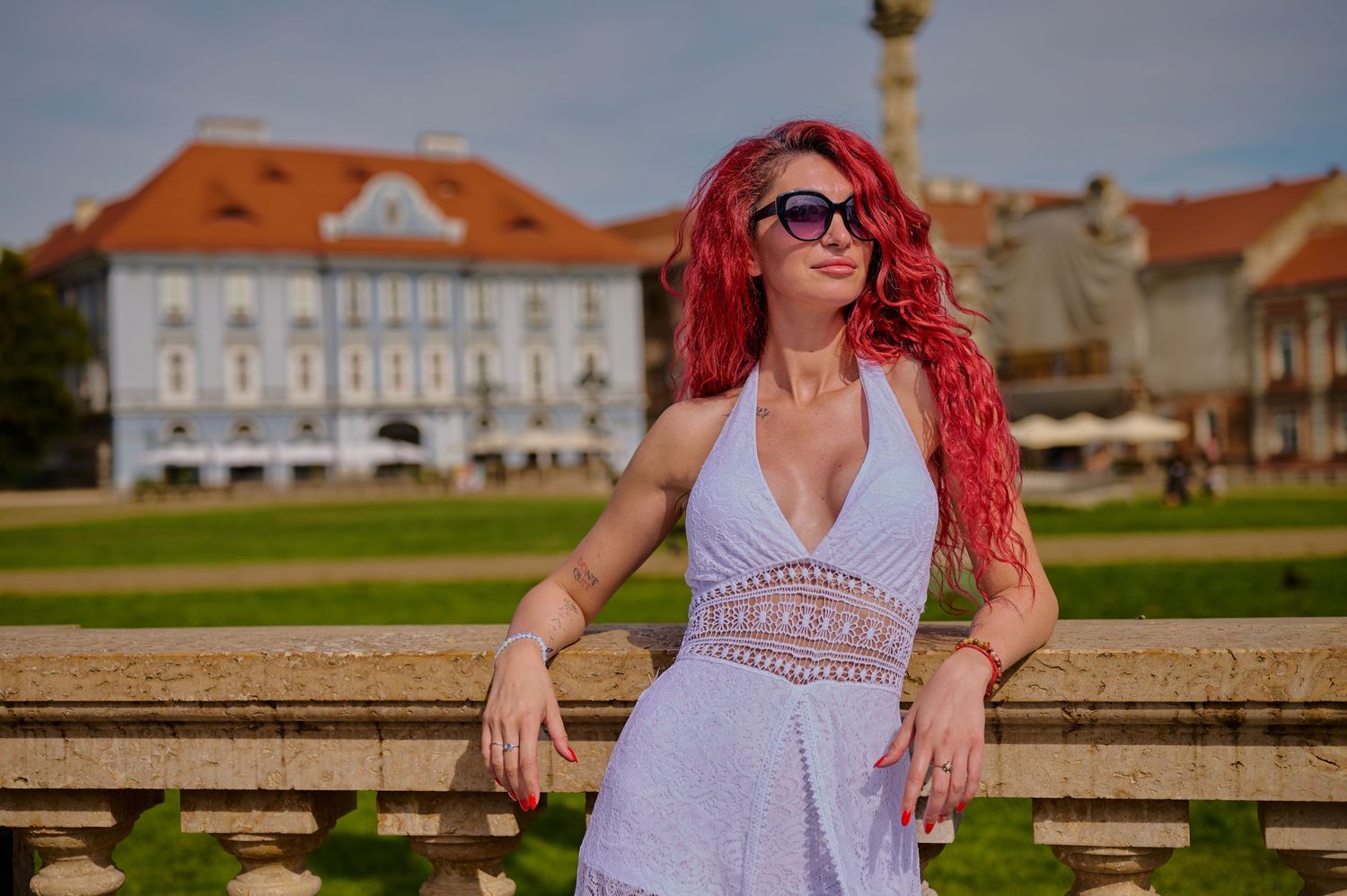 Portret feminin în Piața Unirii din Timișoara, realizat în lumină dură cu arhitectura în spate.