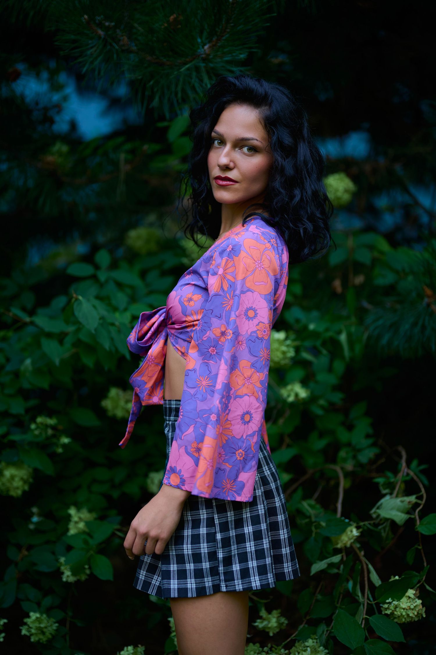 Portret feminin în vegetație, cu lumină naturală și atmosferă intimă.