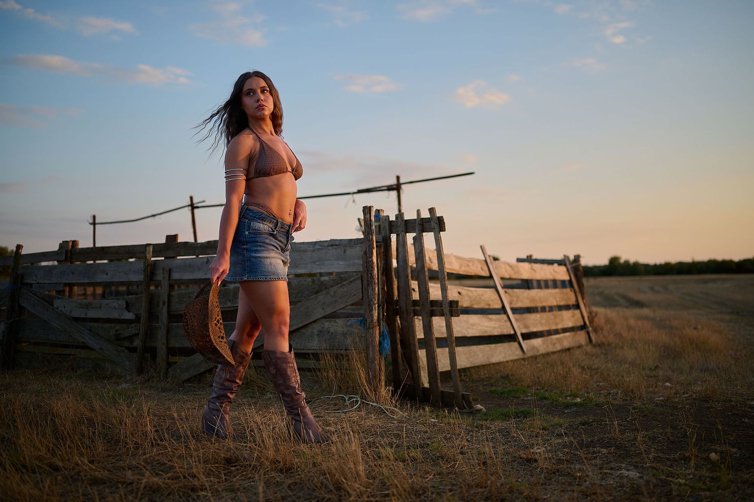 Portret feminin în peisaj rural, cu lumină naturală și compoziție cinematică.