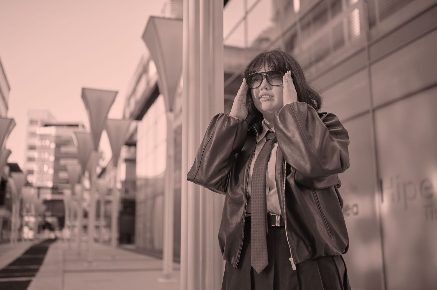 Portret feminin urban, cu ținută dark și atitudine puternică, fotografiat într-un cadru industrial.