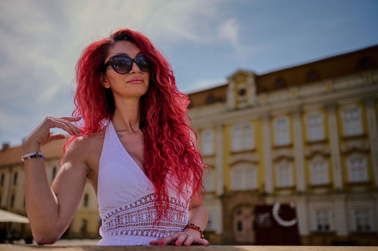 Portret feminin în Piața Unirii din Timișoara, realizat în lumină dură cu arhitectura în spate.