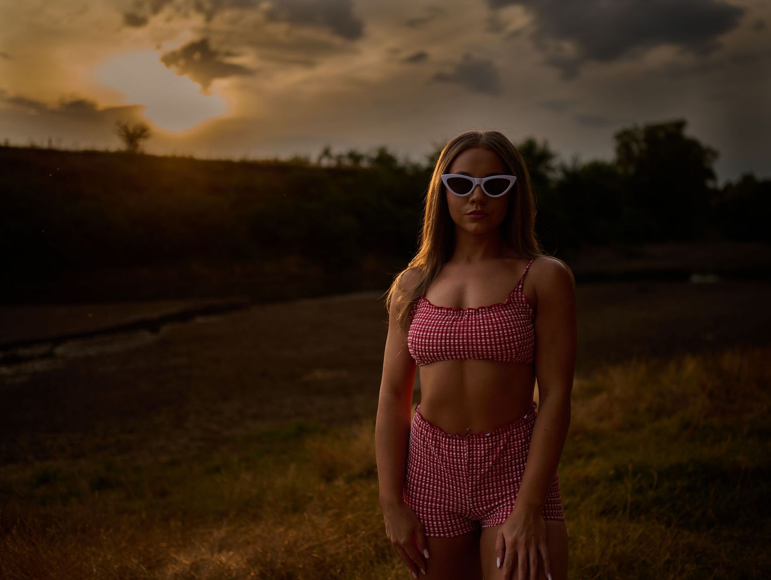 Portret feminin într-un câmp la apus, cu lumină caldă și atmosferă cinematică, realizat în Giroc.