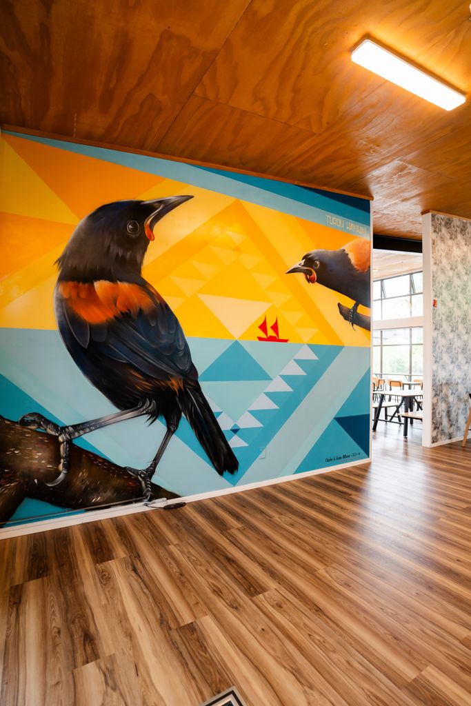 Vibrant wall mural featuring red-winged blackbirds with geometric patterns in a modern interior.