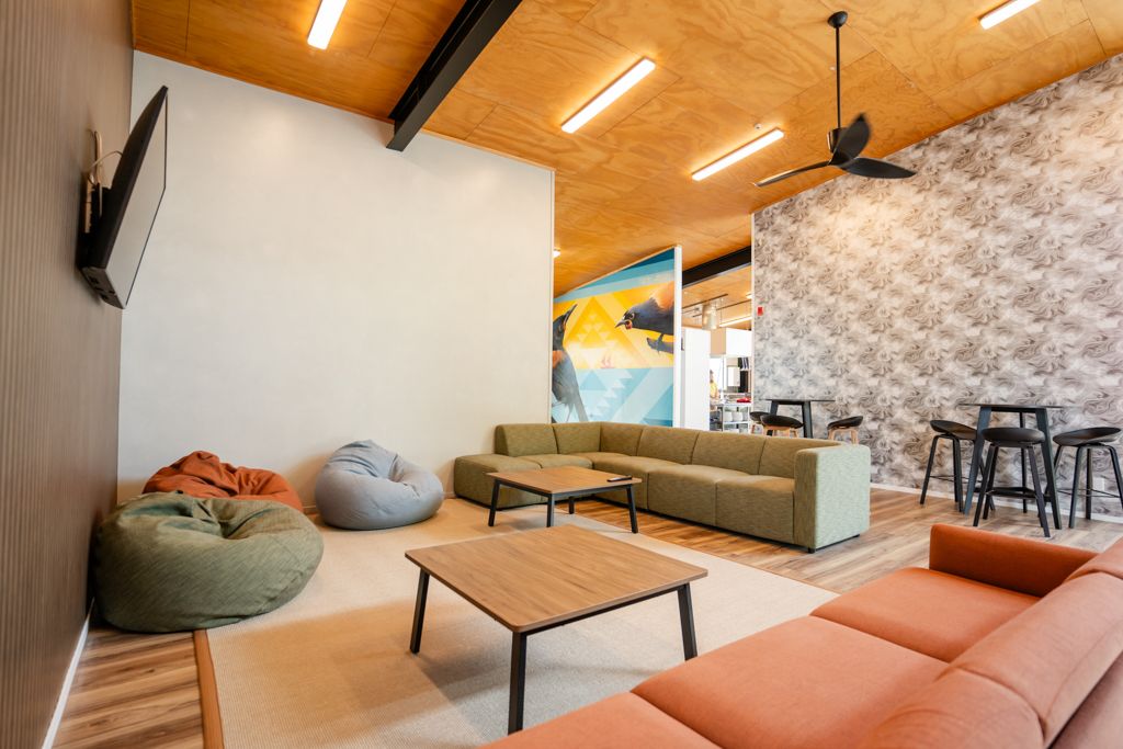 Casual lounge area with bean bags, sectional sofas, and decorative wall mural.