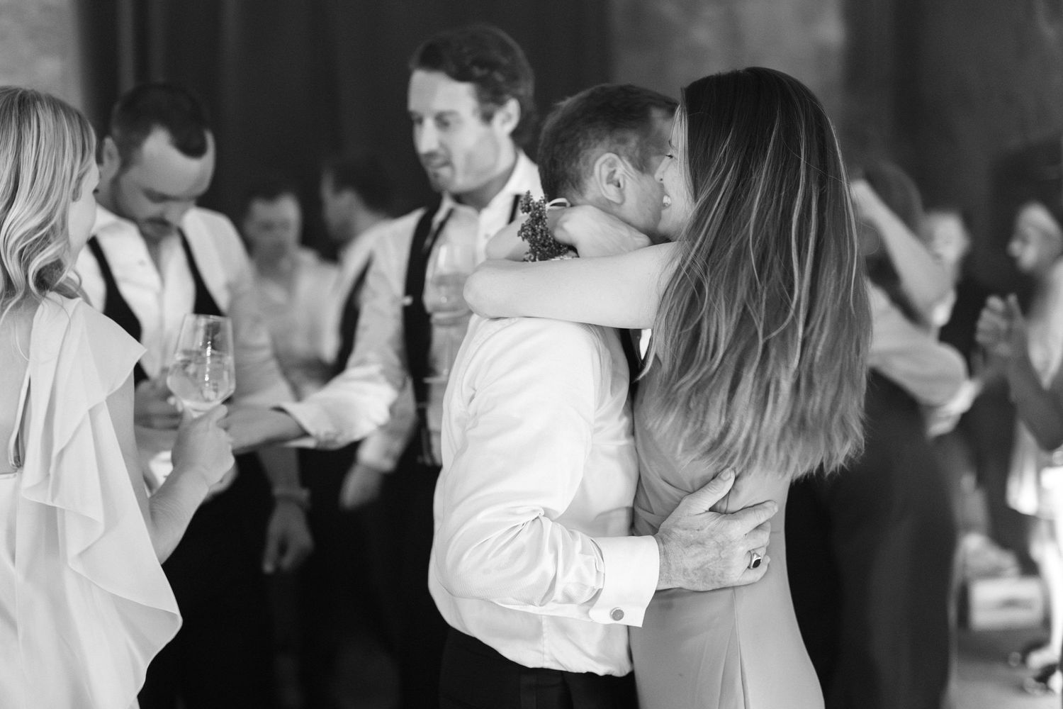 Couple shares a tender embrace on the dance floor at a wedding reception.