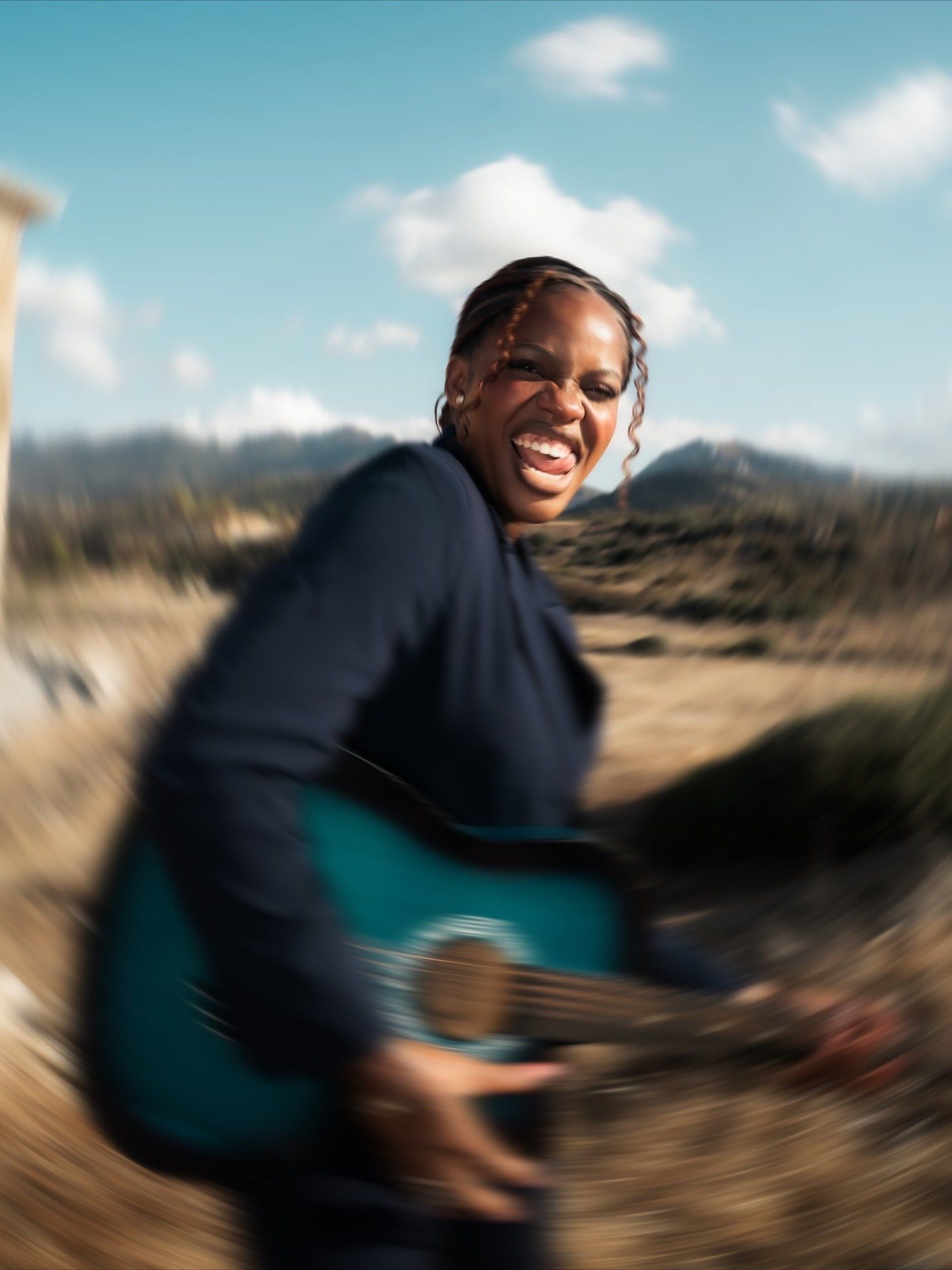 Smiling Black woman playing blue acoustic guitar outdoors with motion blur effect and blue sky behind.