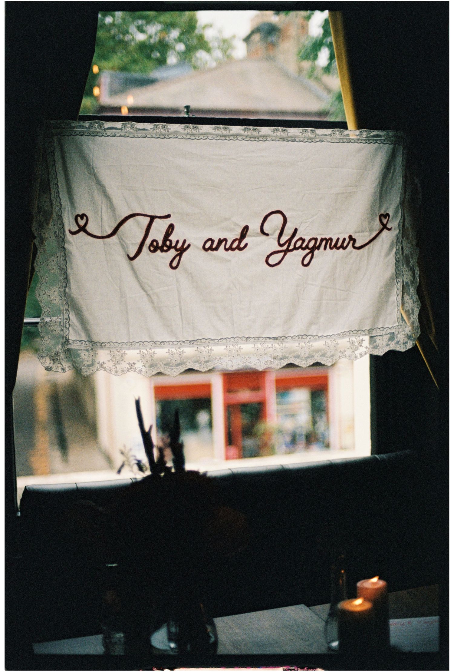 Handmade lace banner reading Toby and Yagmur in cursive script, displayed in a window at a wedding venue.
