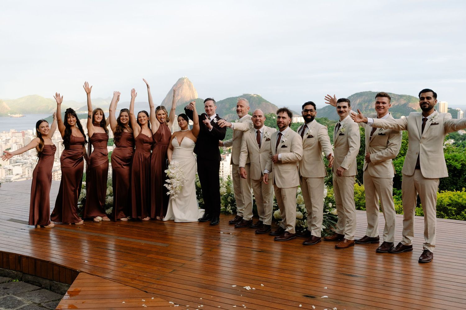Wedding party poses on wooden deck with Sugarloaf Mountain backdrop in Rio de Janeiro.