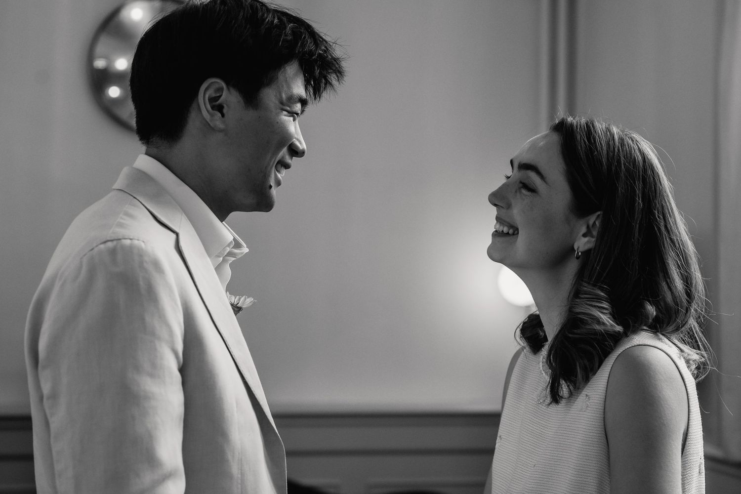 Black and white photo of smiling bride and groom sharing a joyful moment together.