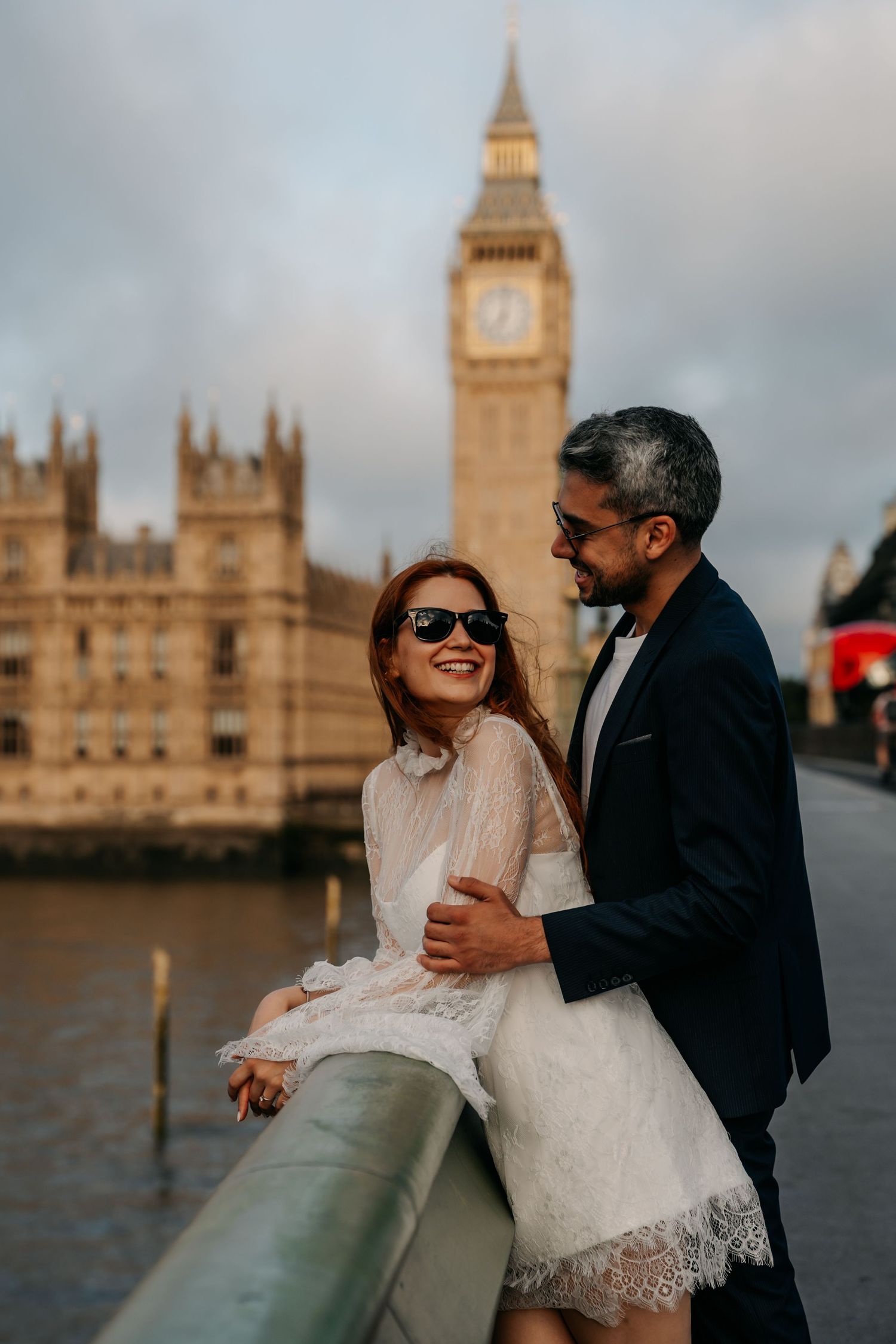 Couple embracing on Westminster Bridge with Big Ben and Houses of Parliament in background, London.