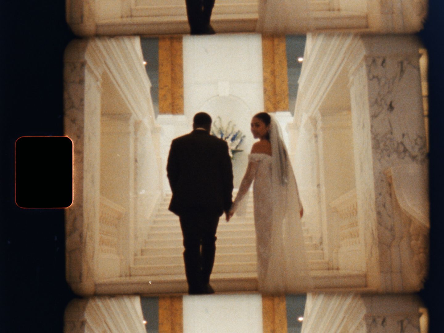 Bride and groom walking hand in hand through grand marble hallway in cinematic film style.