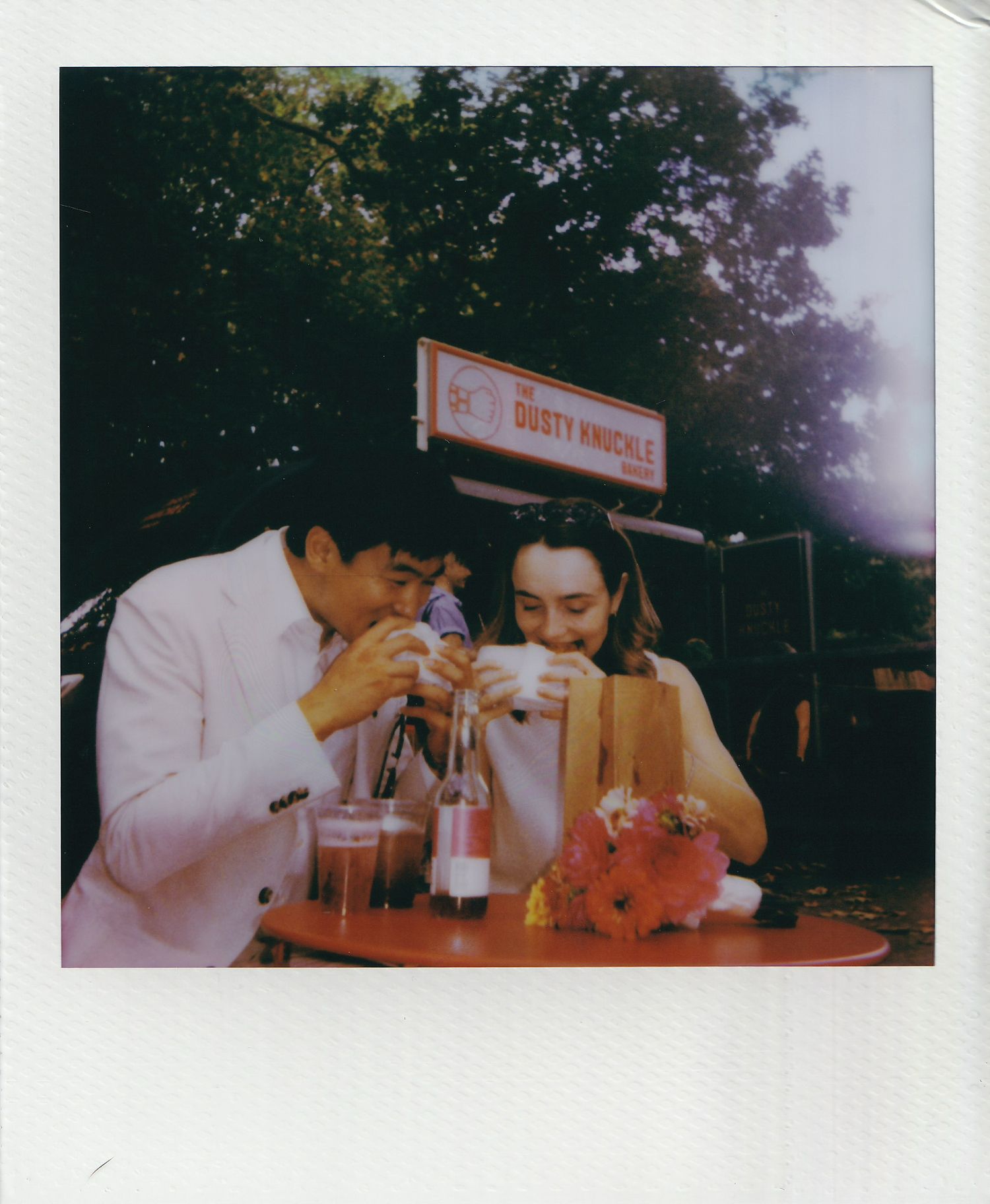 Couple sharing drinks at Dusty Knuckles cafe in a vintage Polaroid style wedding photo.