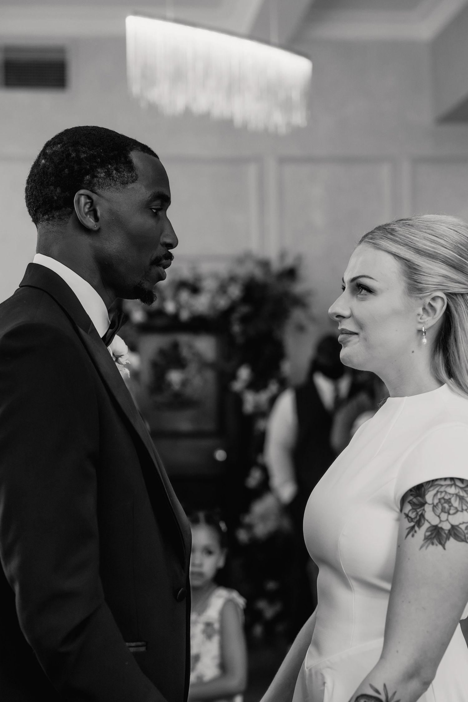 Black and white portrait of bride and groom exchanging heartfelt vows during wedding ceremony.