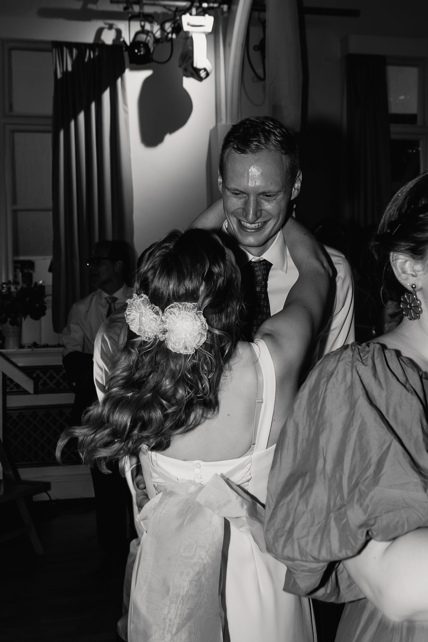 Black and white photo of bride and groom sharing a tender dance at their wedding reception.