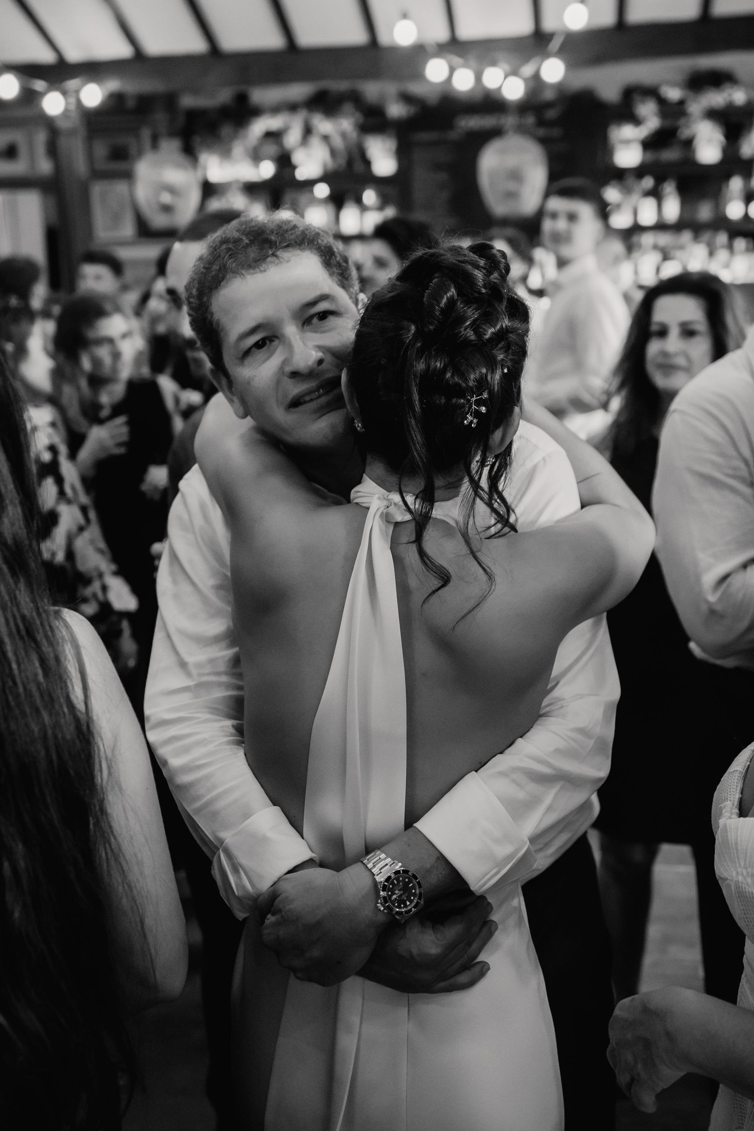 Couple sharing an emotional embrace on the dance floor at their wedding reception in black and white.