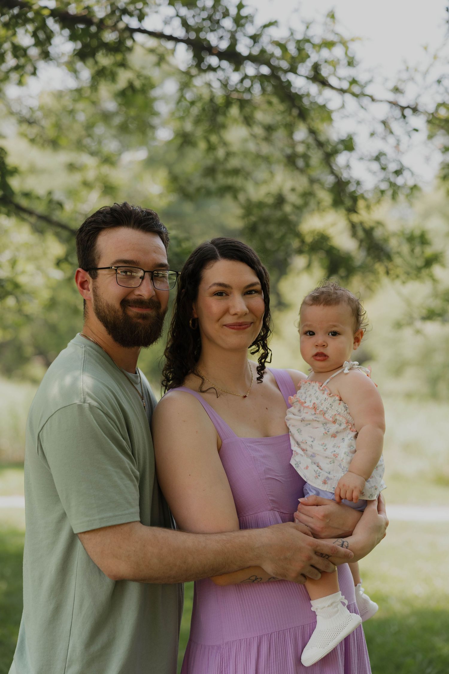 Family of three embracing during an outdoor photo session