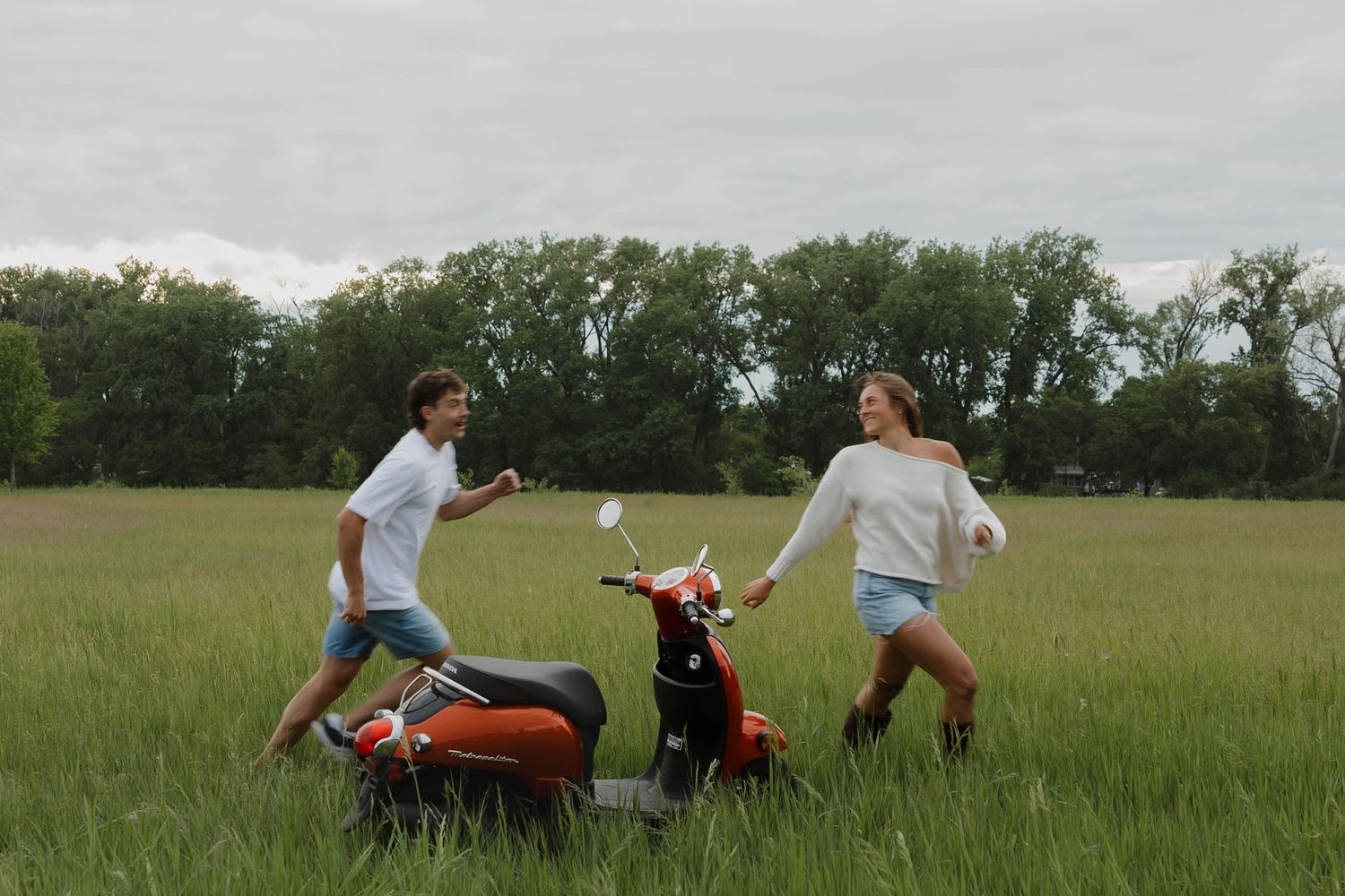 Couple playfully running surrounded by greenery