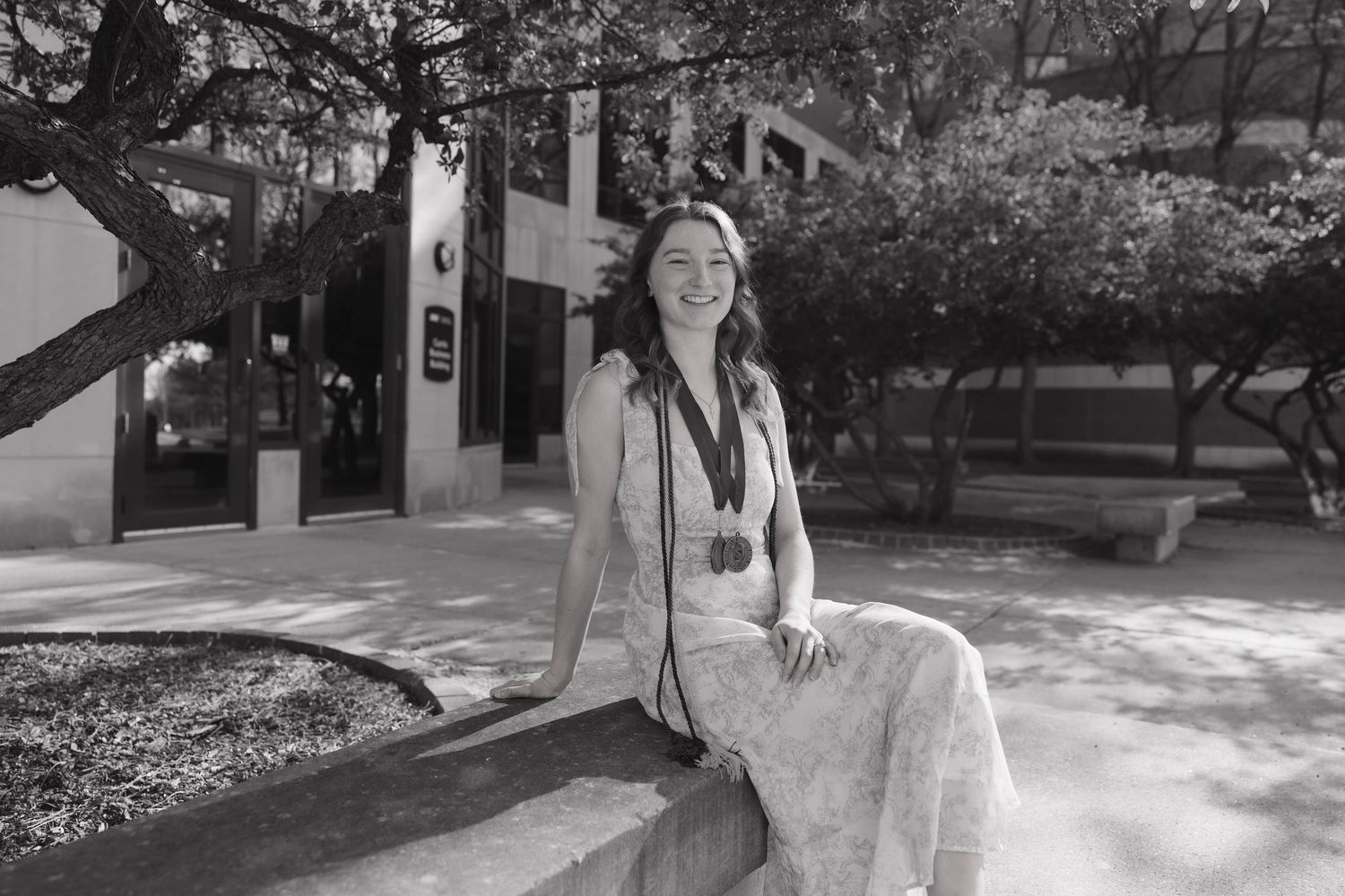College senior posing near University of Northern Iowa architecture