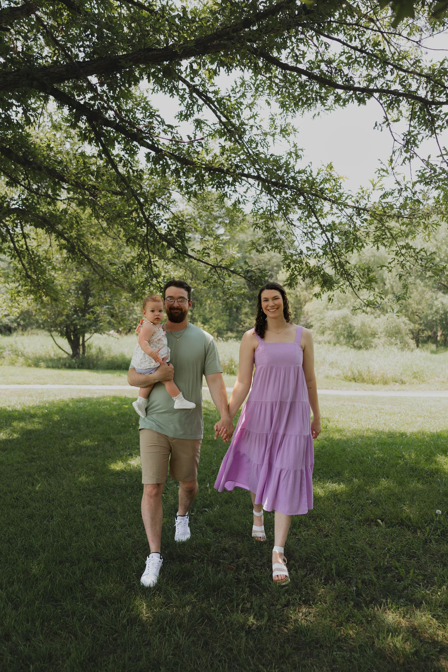 Family of three walking together through the park