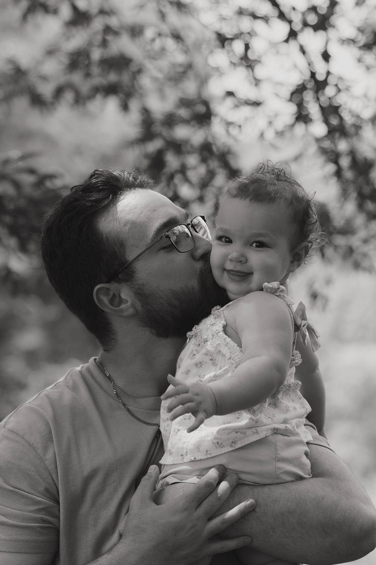 Father holding his child while walking through the park