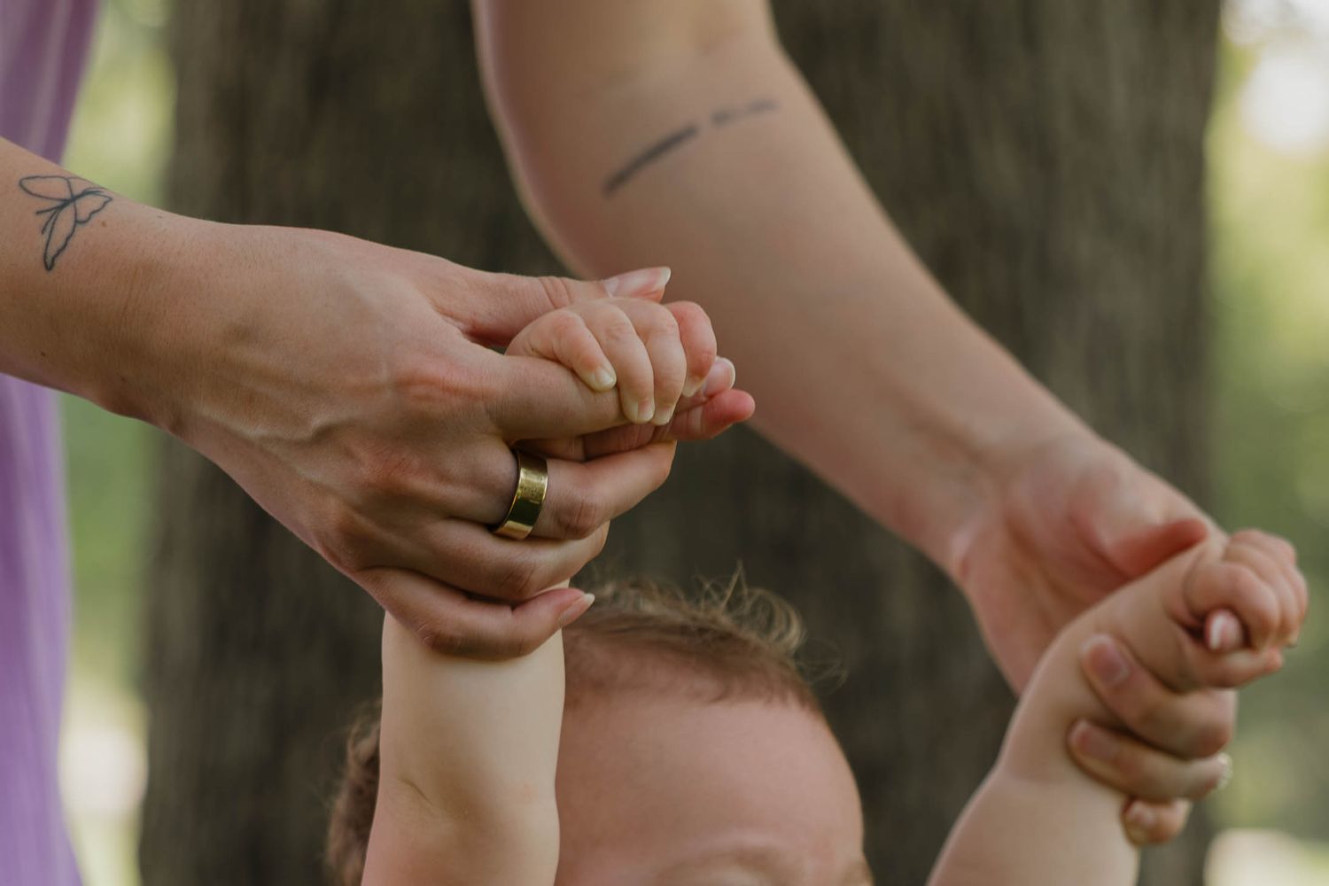 Toddler holds hands with her mother during an outdoor family session