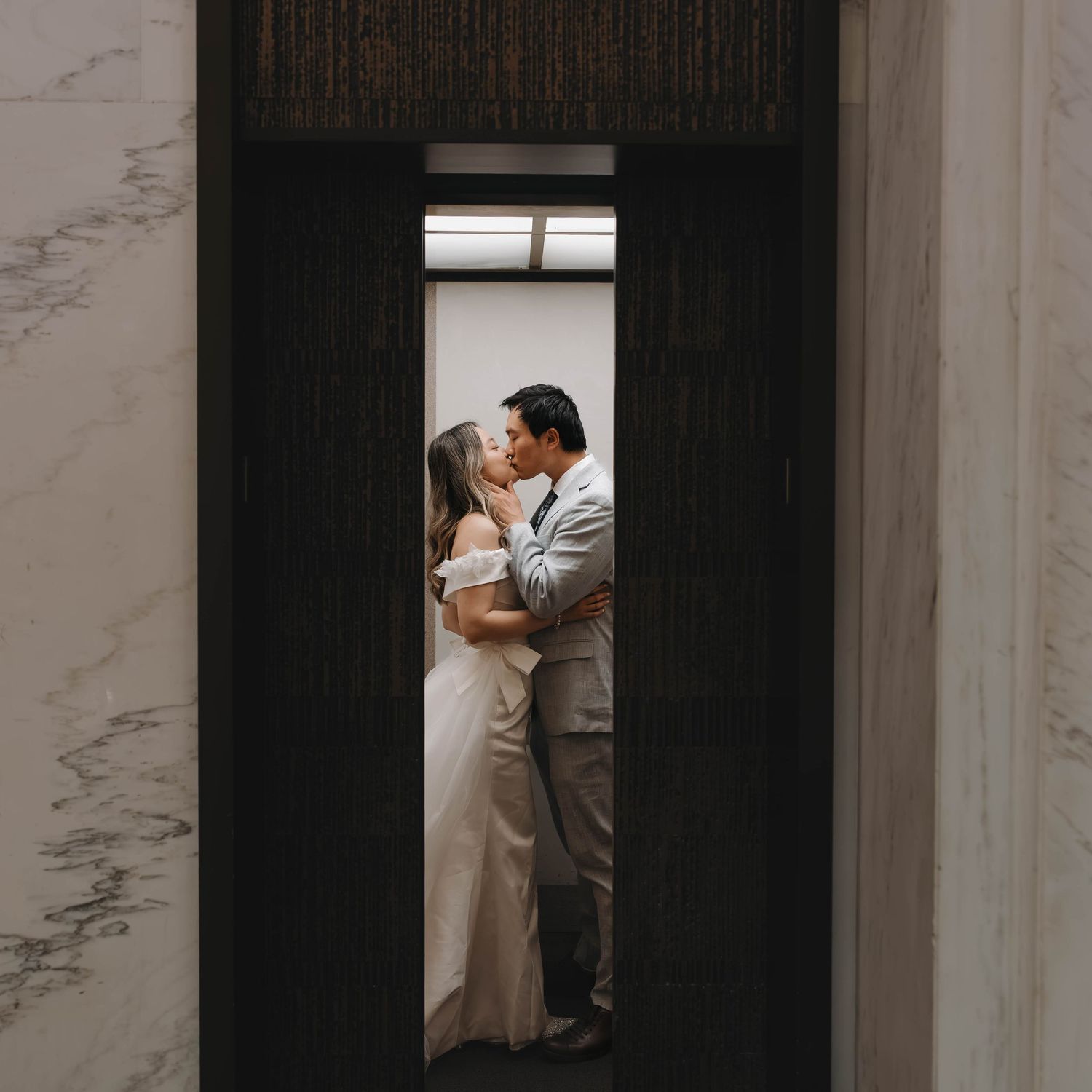 Couple kissing in an elevator during a courthouse wedding in Omaha