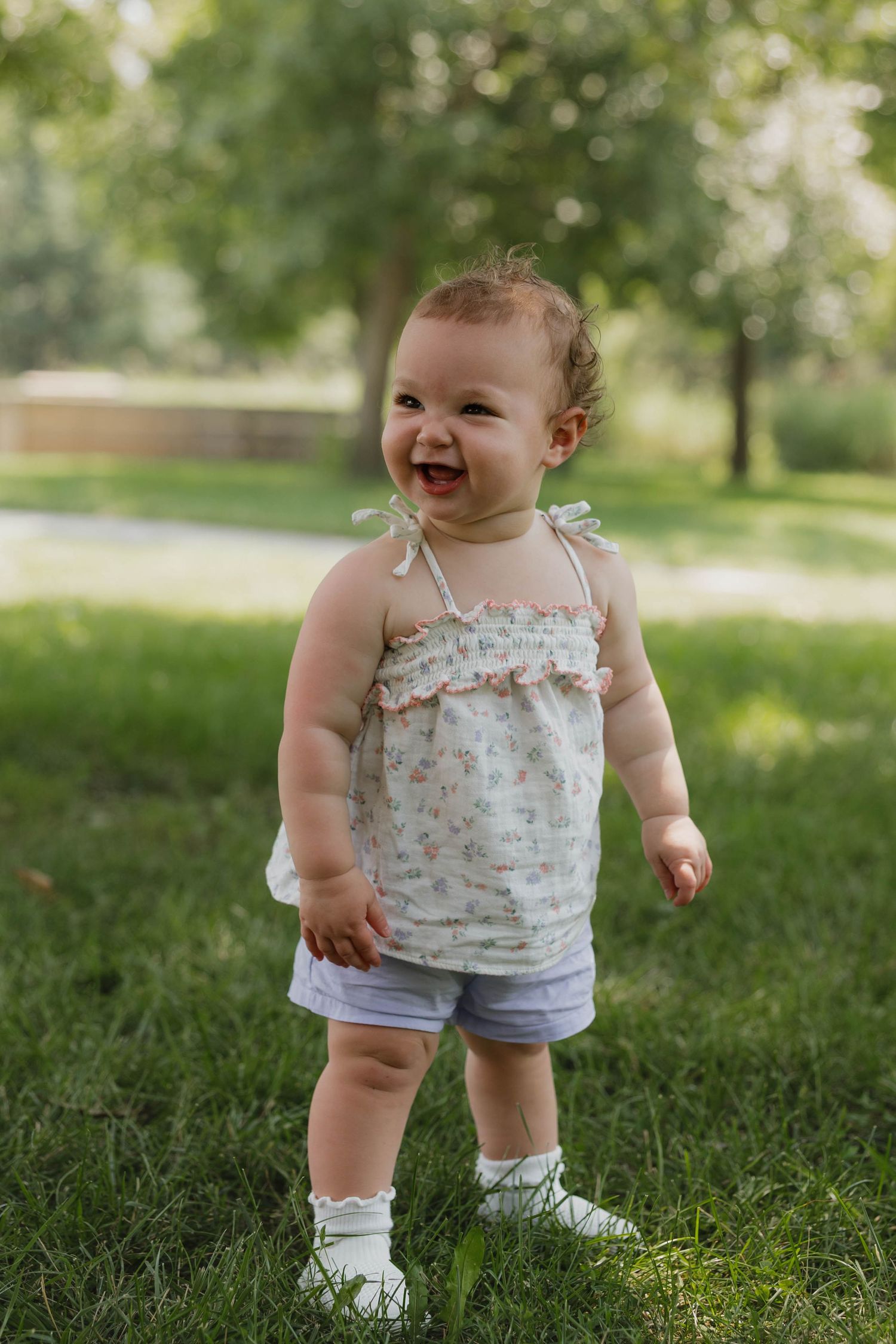 Toddler stands in a park during an outdoor family session