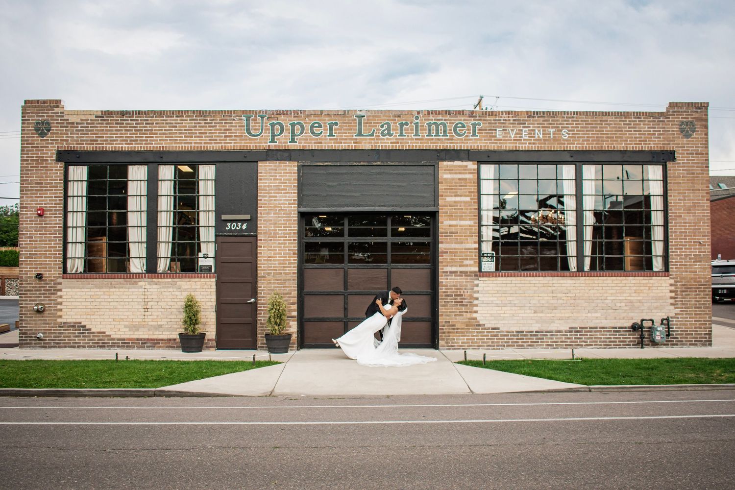 Bride and groom sharing a kiss in front of the Upper Larimer building in Denver, Colorado.