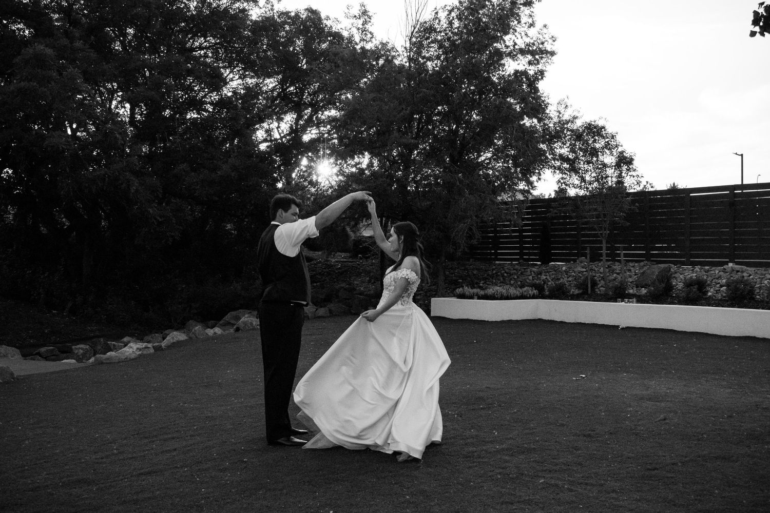 Black and white photo of bride and groom sharing a romantic dance outdoors at their wedding reception at Creekside Terrace by Wedgewood