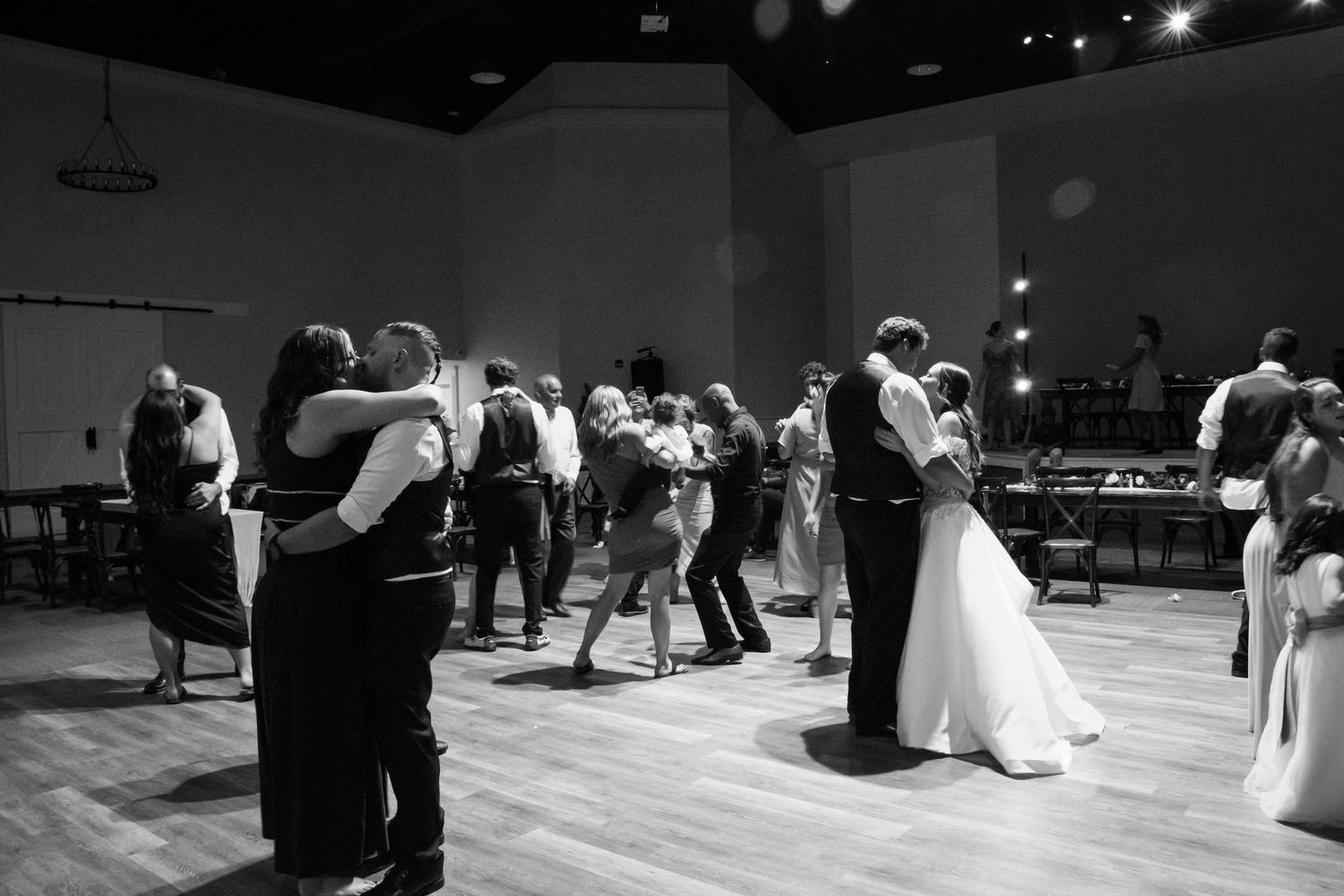 Couples fill the dance floor during a wedding reception in a black and white photo at Creekside Terrace by Wedgewood
