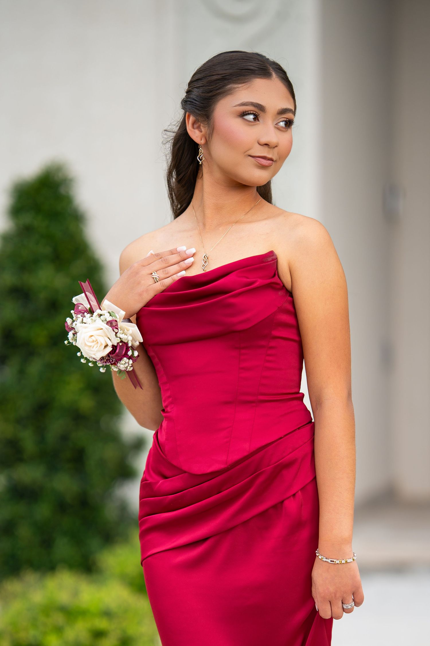 Young woman in an elegant red formal dress posing for a special occasion portrait