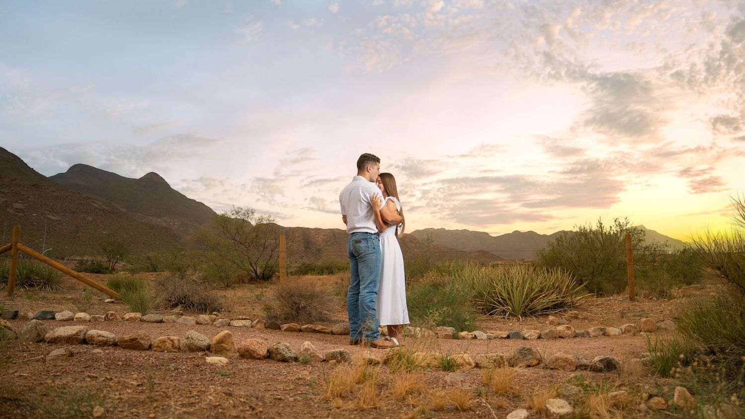 Couple embracing at sunset with the El Paso mountains in the background