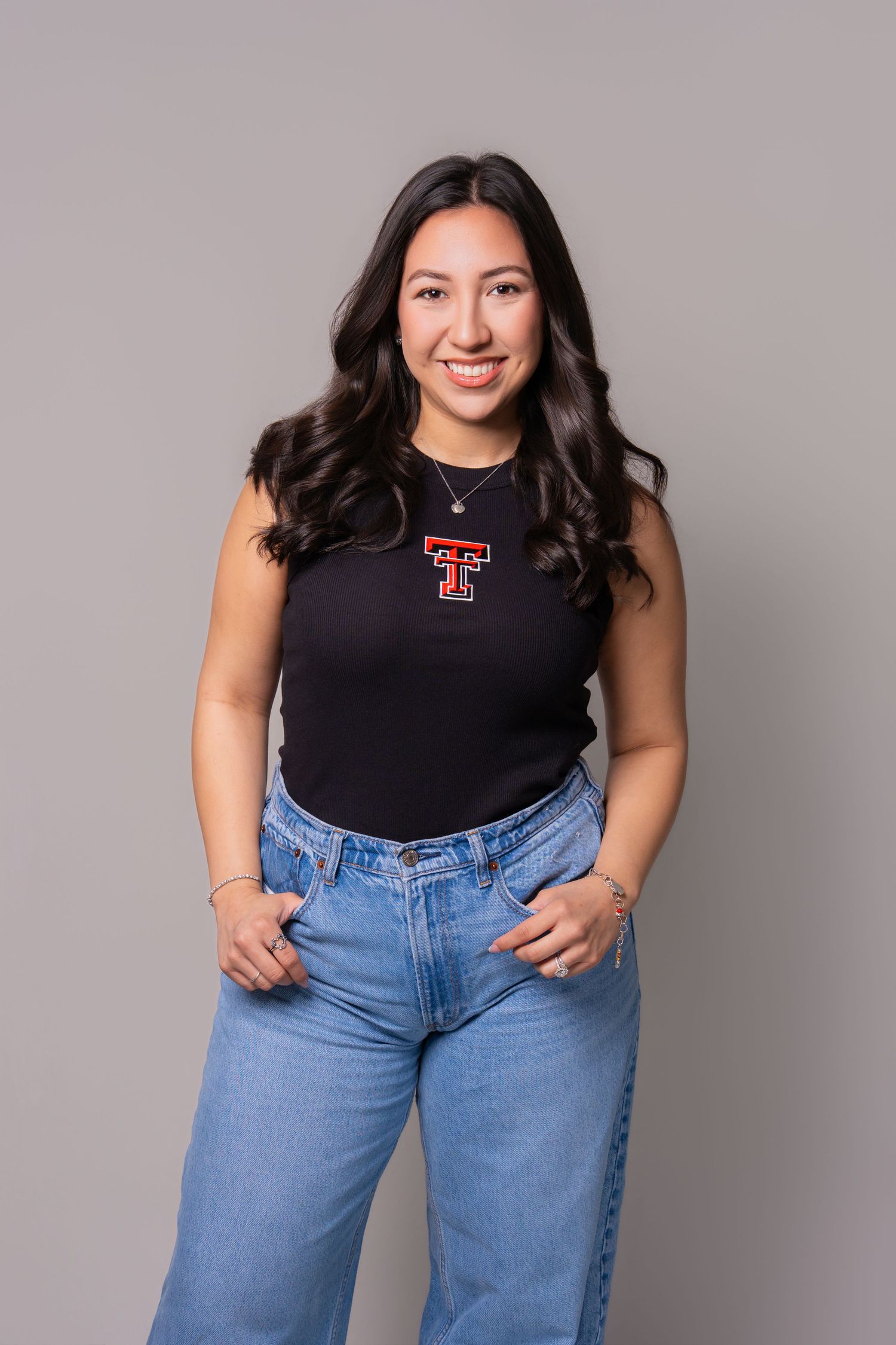 Professional portrait of a woman wearing a Texas Tech shirt against a studio background