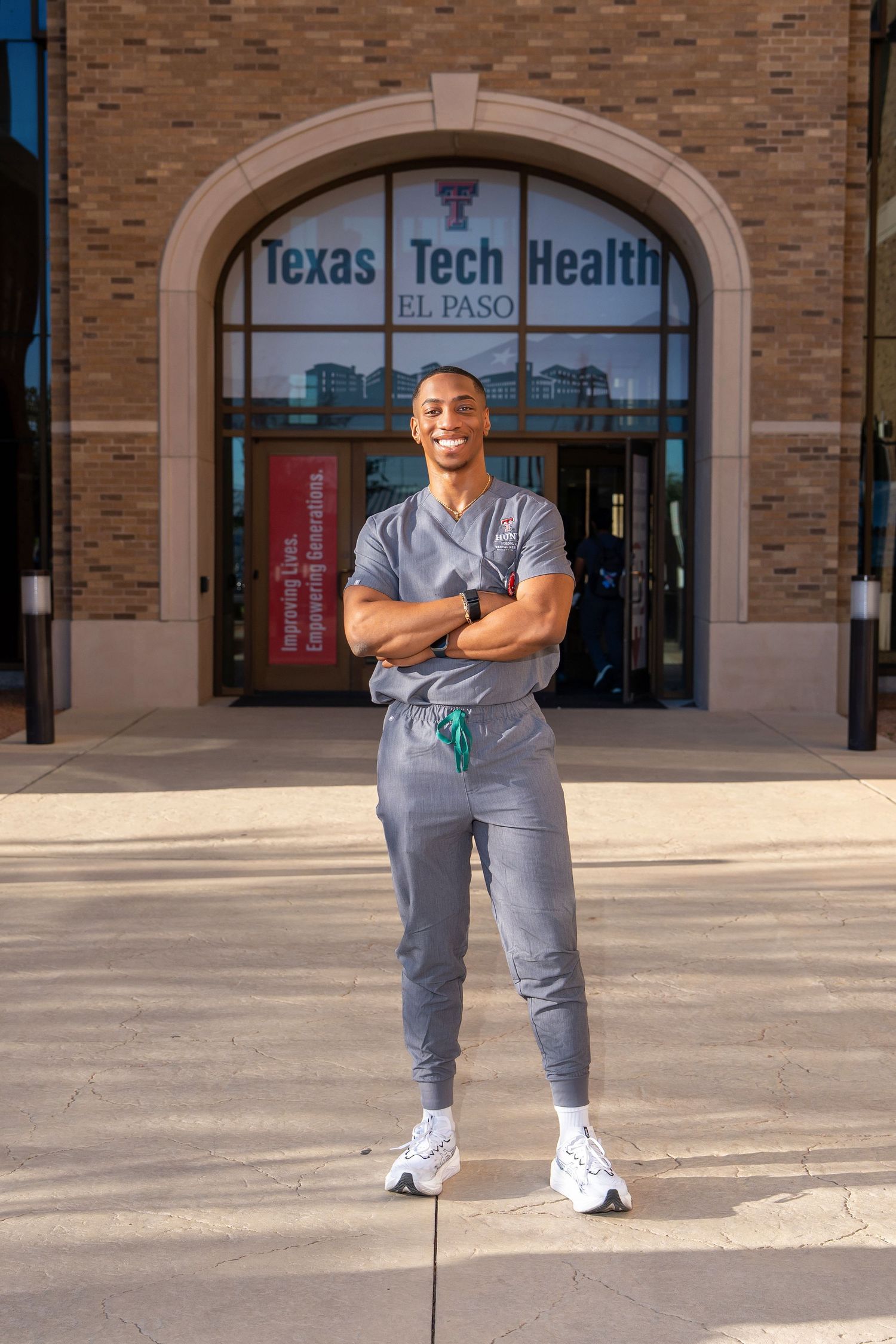 Medical professional in scrubs posing outside Texas Tech Health El Paso