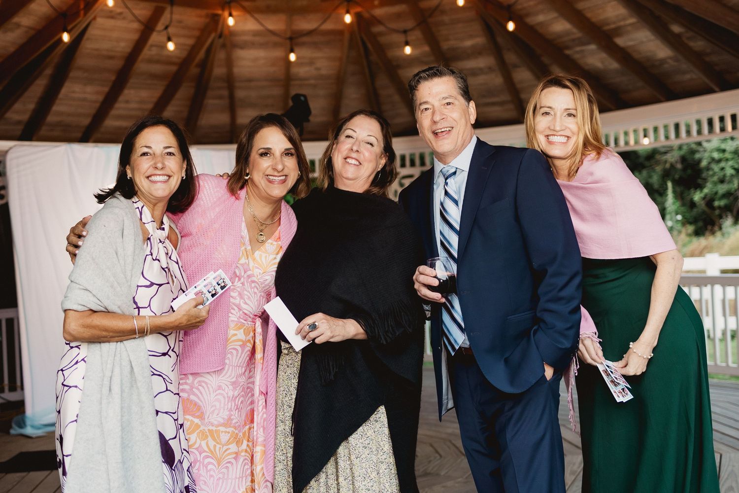 A series of candid wedding reception photos showing guests dancing and celebrating at an outdoor venue.