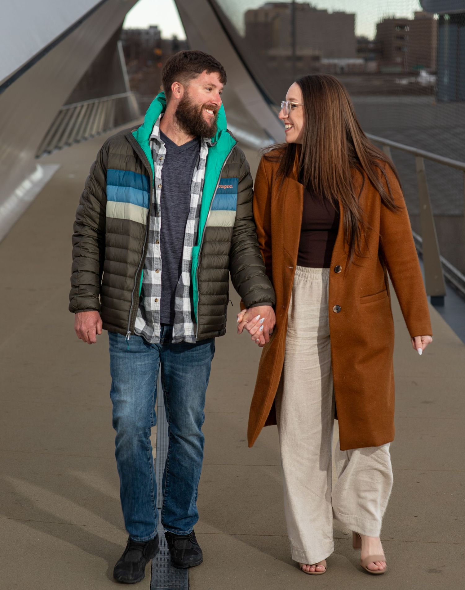 Urban couple photography on a modern bridge, captured by a creative portrait photographer in Colorado Springs.